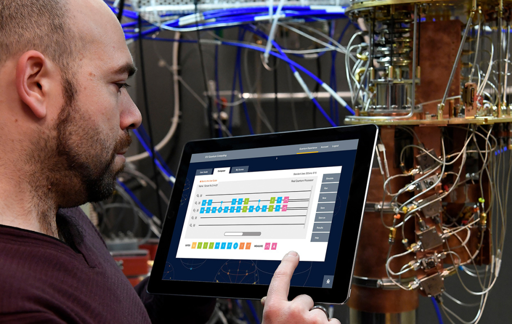 Man working on tablet near quantum computer