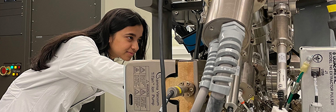 Female student studying machine in lab
