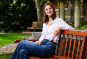 Student ambassador Benedetta posing on a bench in the faculty garden